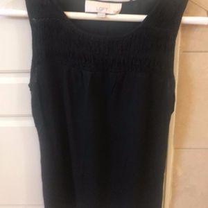 Black sleeveless top with ruched detailing.